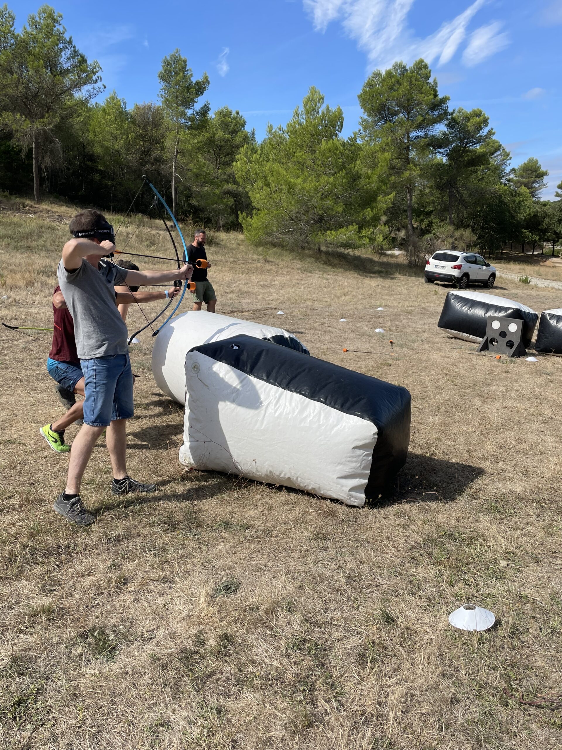 Vue rapprochée d’un joueur tirant une flèche à embout mousse en plein cœur d’une partie intense d’Archery Tag.