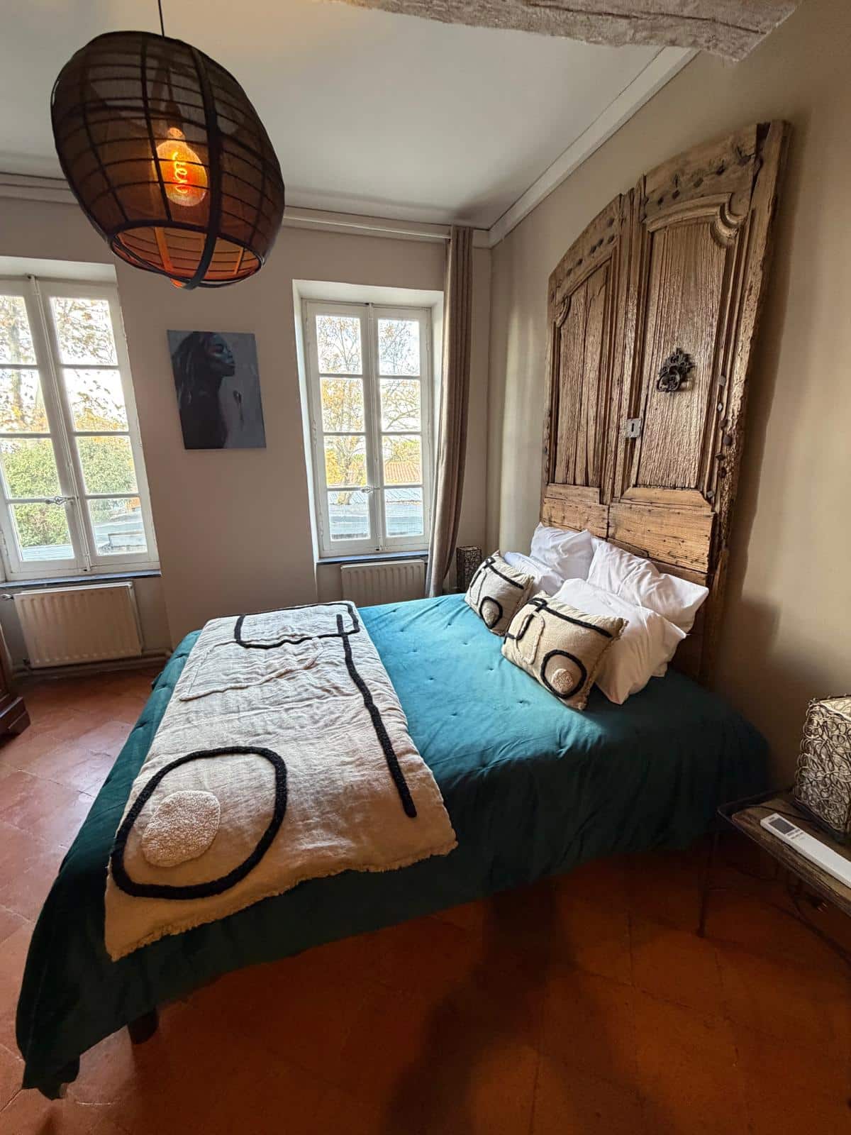 Chambre cosy avec lit et décoration rustique.
